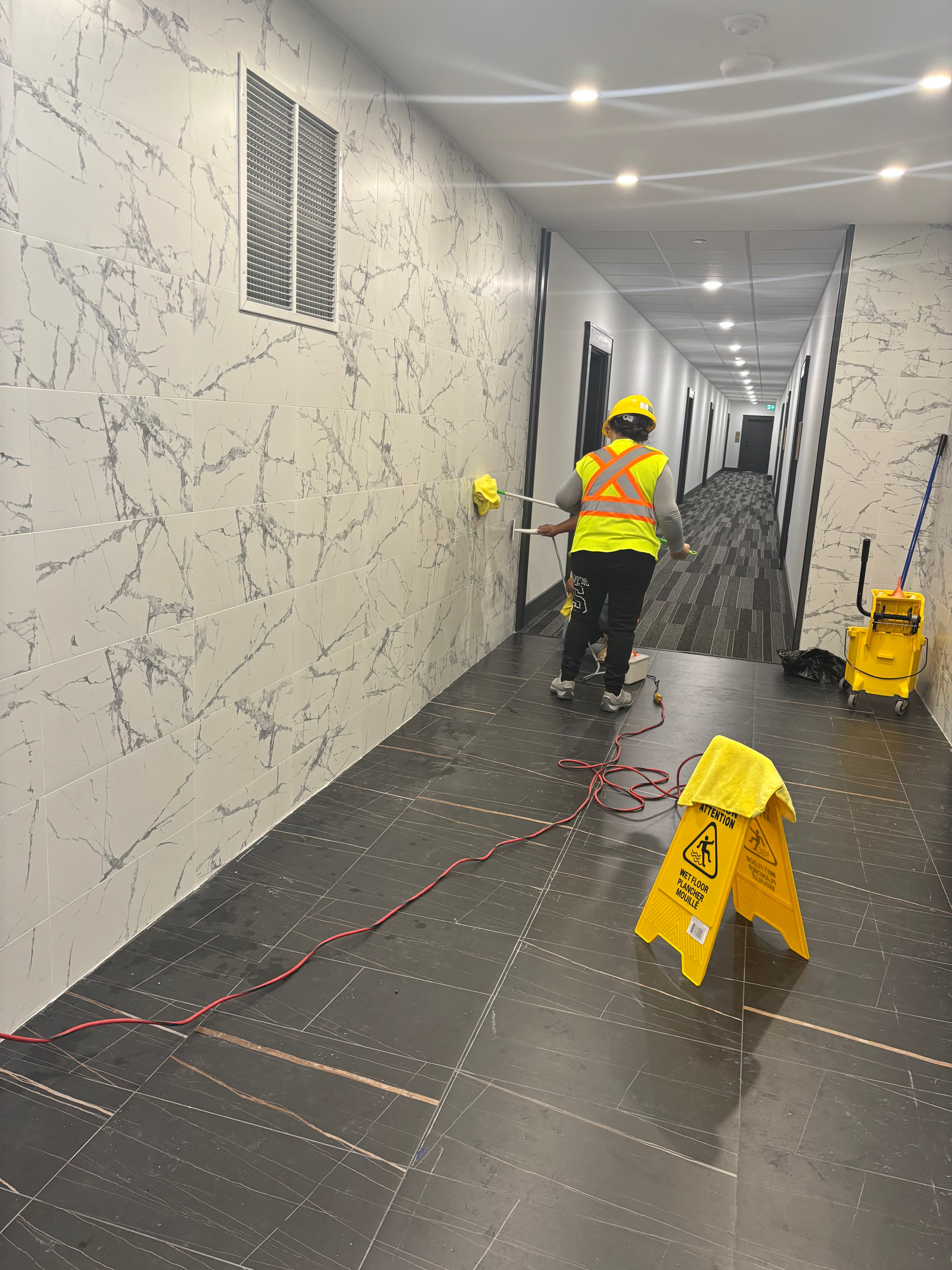 Red and White Cleaning team at work in a professional building corridor