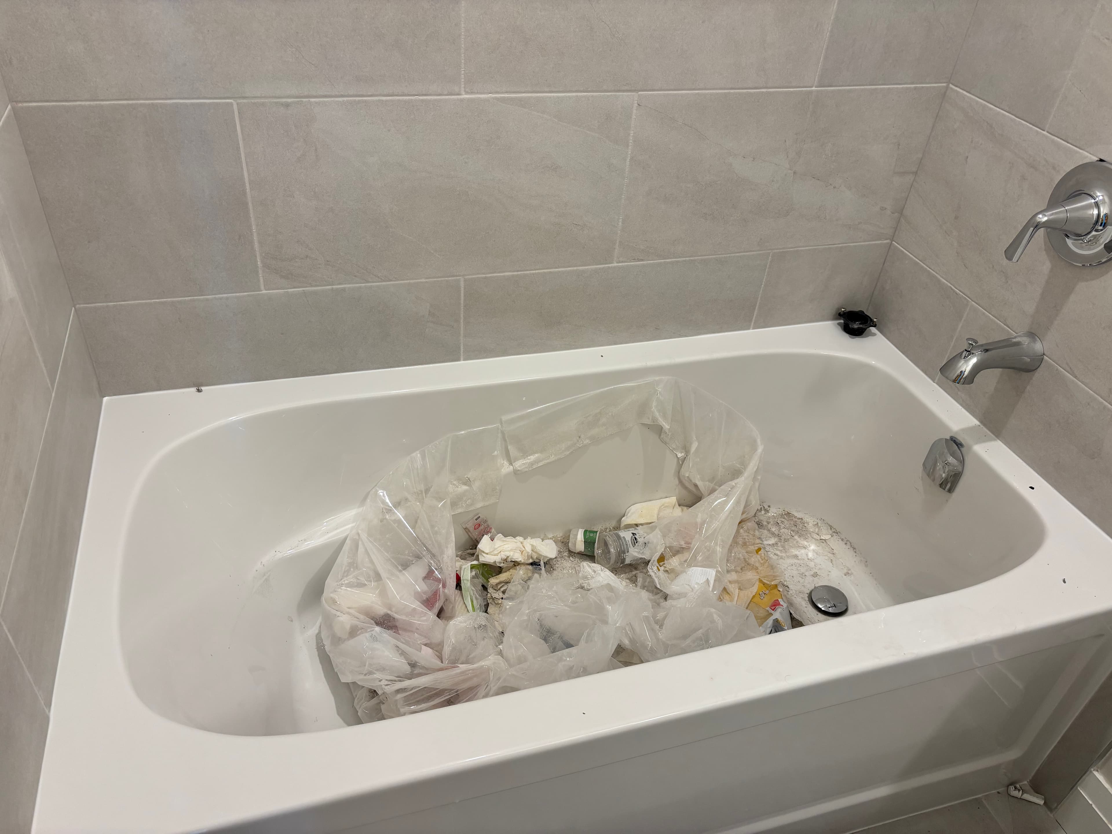 Construction debris in bathtub — typical Phase 1 post-construction cleanup at Tricar Guelph